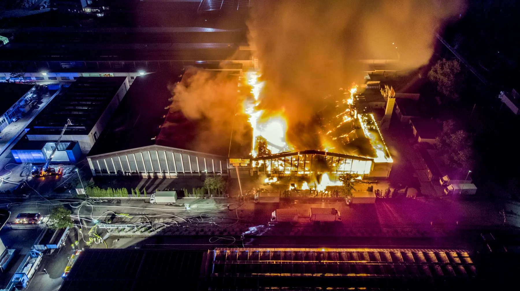 Industrial factory engulfed in flames at night, illustrating the scale of loss that underinsured plant and equipment can create